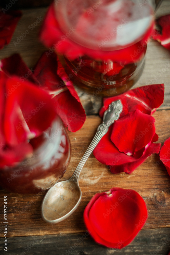 Jar of rose petal jam on a wooden table