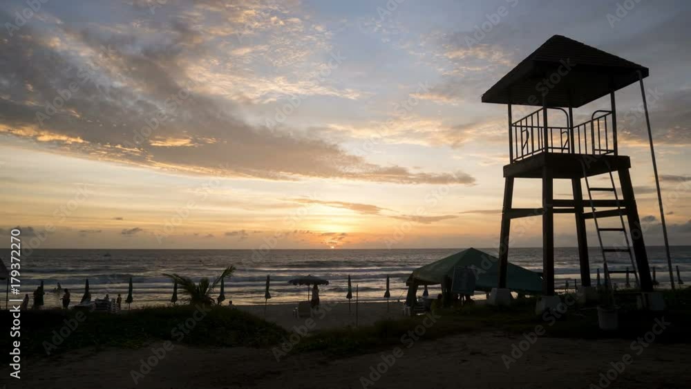 4K Time - lapse zoom out shot life guard tower on the beach with cloud movement and sunset . 4K Time - lapse zoom out shot life guard tower on the beach with cloud movement and sunset .