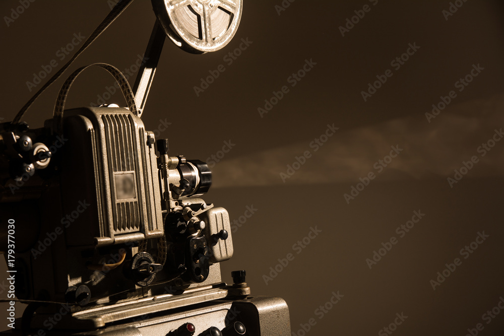 Naklejka premium Old cinema projector on a dark background