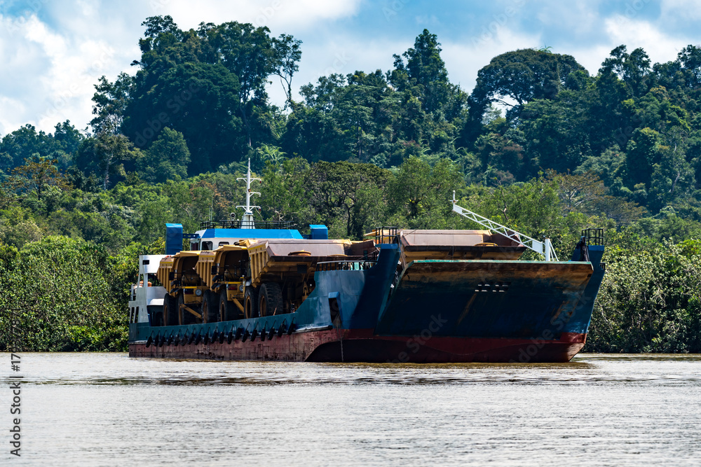 Boat carrying huge trucks for coal transportation in Berau, Kalimantan Boat carrying huge trucks for coal transportation in Berau, Kalimantan