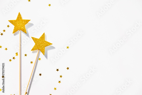 Two golden party magic wands and sequins on a white background. Copy space. photo