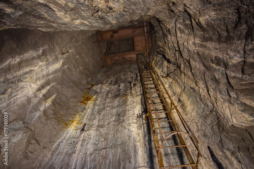 Underground abandoned ore mine shaft tunnel gallery with the stairs ladder
