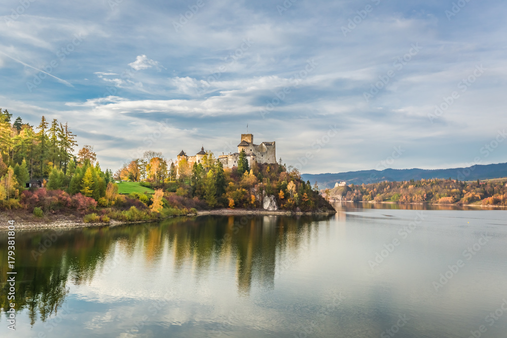 Beautiful castle by the lake at sunset in autumn