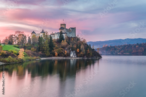 Wonderful castle by the lake at dusk in autumn