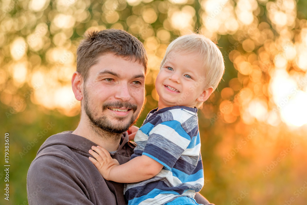 Father and son outdoor portrait in sunset sunlight Father and son outdoor portrait in sunset sunlight