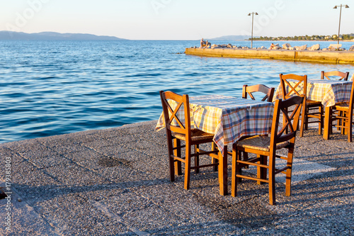 Evening at traditional Greek tavern, restaurant by the open sea © Roman_23203