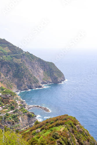 View from mountains to blue sea. Water smashing rocks. Riomaggiore, Italy © frimufilms