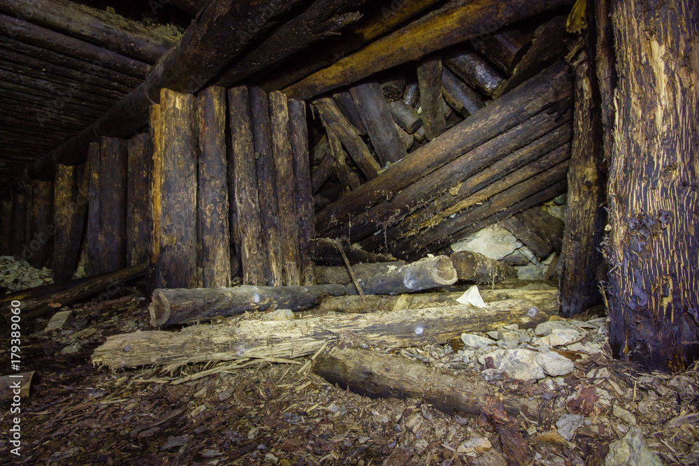 Abandoned old chromite mine shaft tunnel with wooden timbering