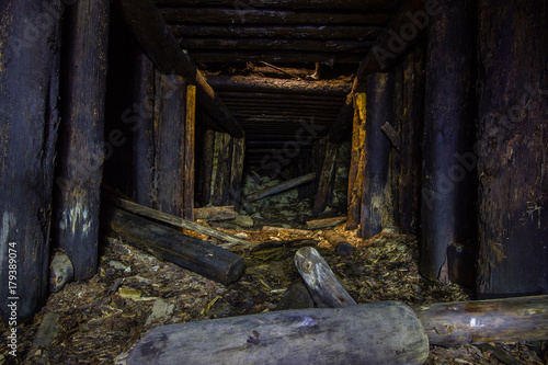 Abandoned old chromite mine shaft tunnel with wooden timbering