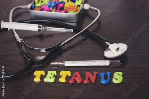 colorful letter tetanus and thermometer,stethoscope,syringe,metal box of letters photo