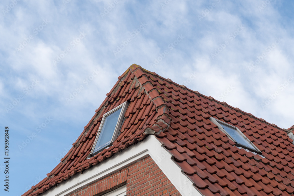 Fenster eines Hauses mit roten Dachziegeln und Backsteinen Fenster eines Hauses mit roten Dachziegeln und Backsteinen