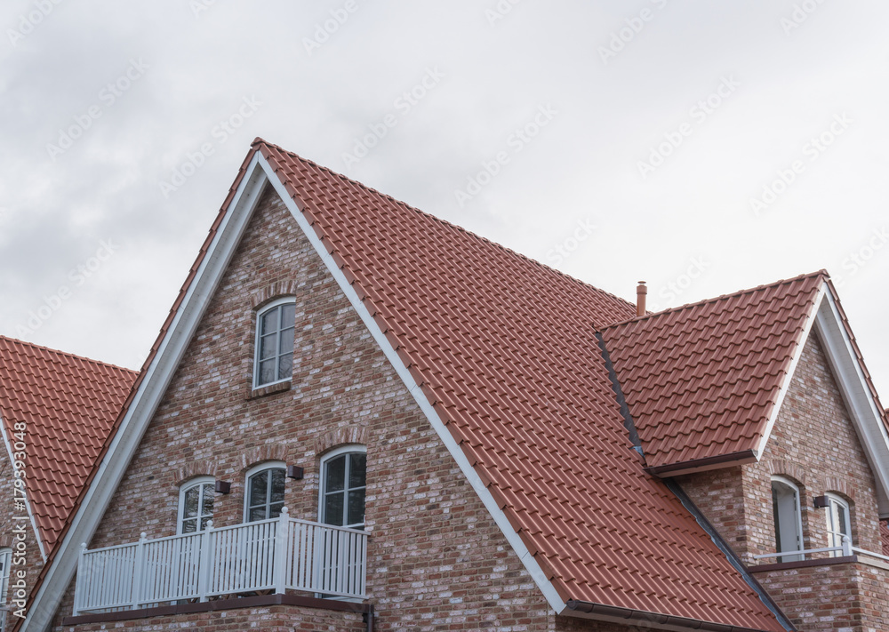 Fenster eines Hauses mit roten Dachziegeln und Backsteinen