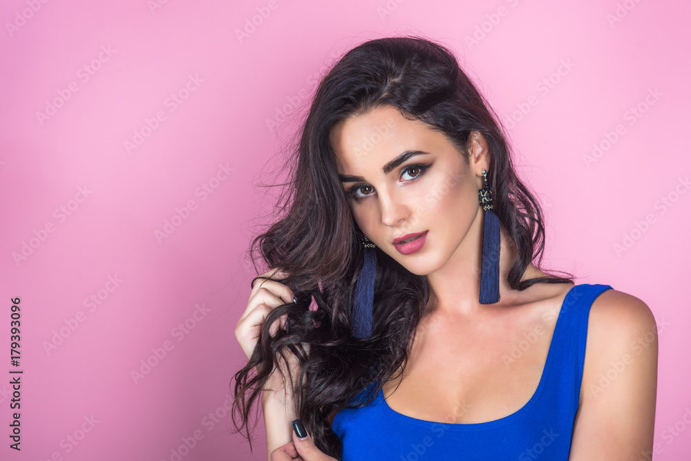 Woman with makeup face in blue dress on grey background Woman with makeup face in blue dress on grey background