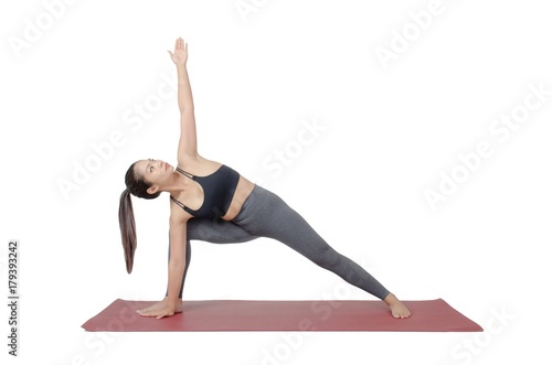 young asian woman doing yoga in Utthita Parsvakonasana or Extended Side Angle Pose yoga pose on the mat isolated on white background, exercise fitness, sport training and healthy lifestyle concept