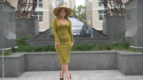 beautiful elegant woman in a green dress and a white hat with marsh paly. high-fashion. 4k