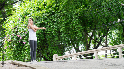 sport woman stretching running in street park city urban background beautiful garden