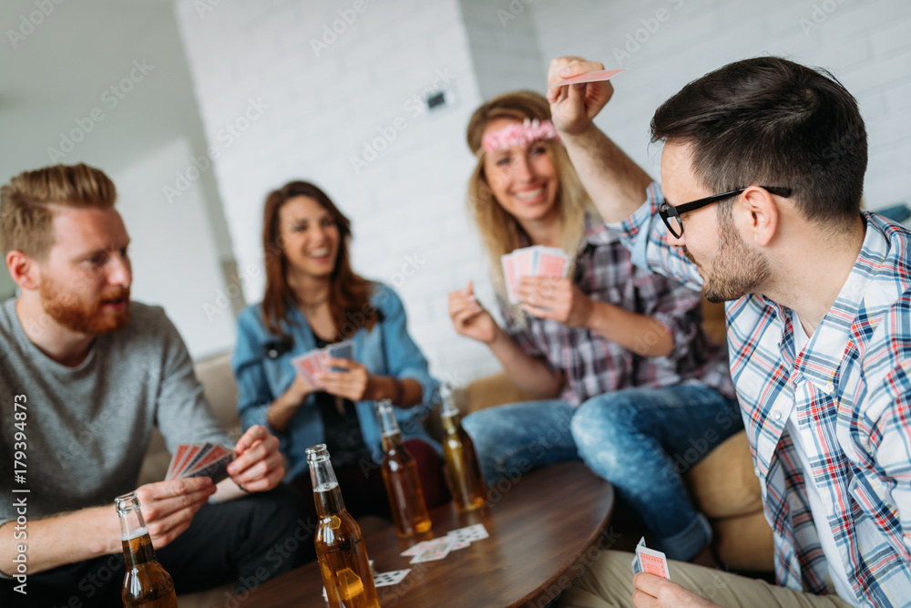 Fototapeta premium Group of friends having fun while playing cards