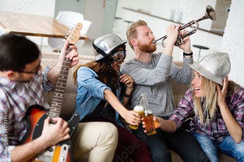 Happy group of friends playing instruments and partying
