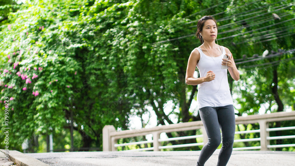 sport woman running in street park city urban background beautiful garden