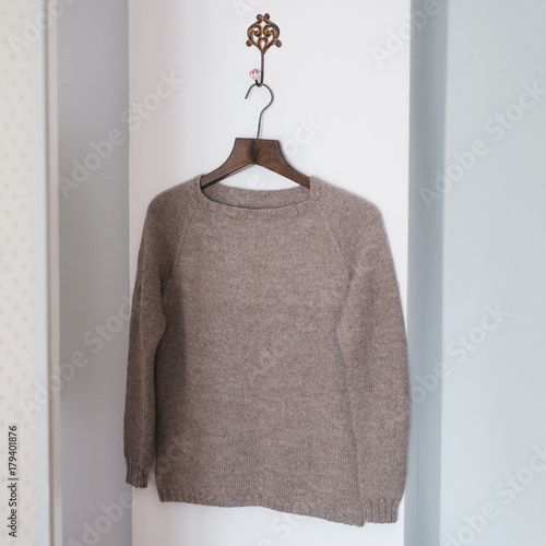 Beige knitted woolen sweater on a hanger