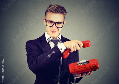 Konstfotografi Annoyed sly young business man hanging up telephone