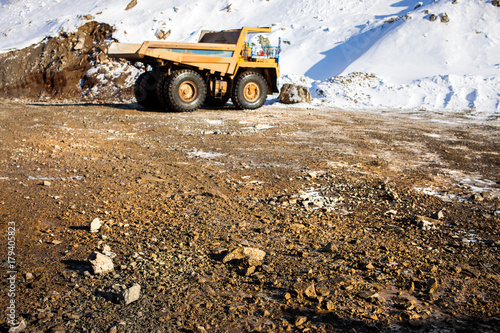 Dump truck on the background and stones on the road on the foreground © yo camon