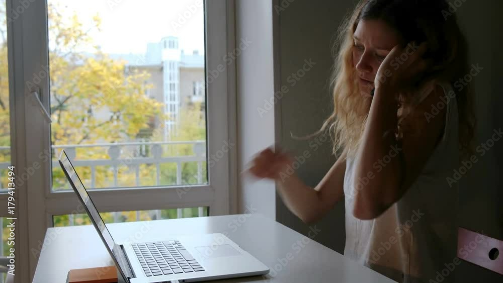 Cute young woman talking with friends via mobile phone while working at a laptop, and find helpful information to prepare for the seminar while sitting at home Cute young woman talking with friends via mobile phone while working at a laptop, and find helpful information to prepare for the seminar while sitting at home