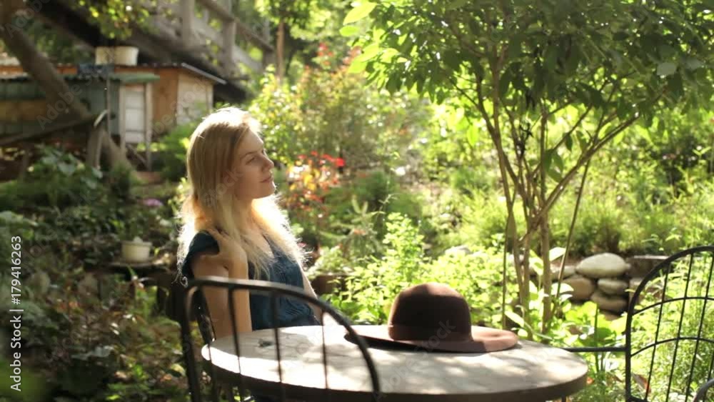 beautiful girl waiting for a waiter in a cafe in the garden beautiful girl waiting for a waiter in a cafe in the garden