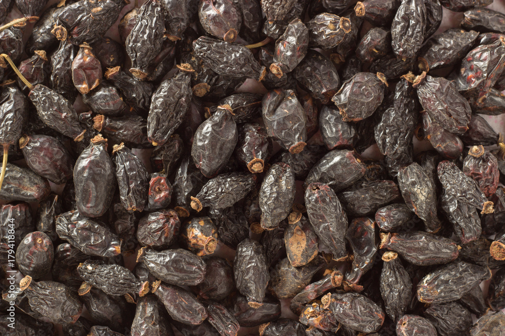 Background of a large quantity of dried rosehip berries and spoon Background of a large quantity of dried rosehip berries and spoon