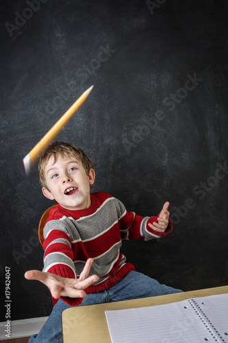 Bild auf Leinwand Young bored boy throwing his pencil in the air