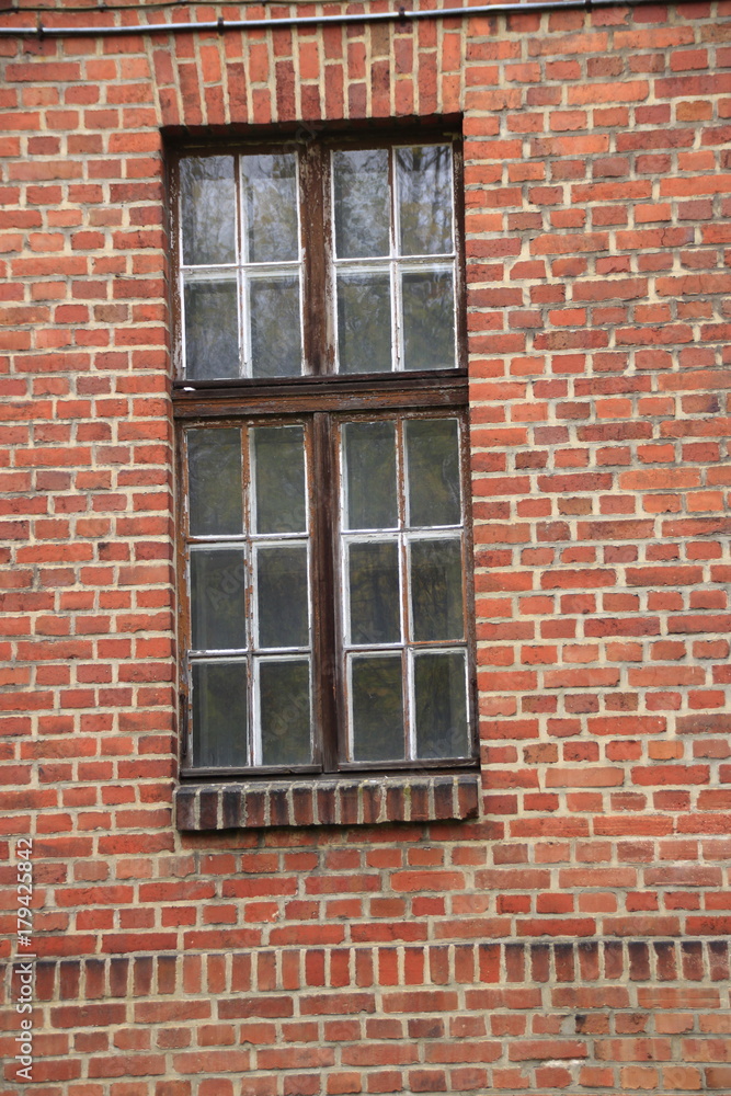 altes glasfenster in einer alten ziegelmauer aus roten ziegelsteinen altes glasfenster in einer alten ziegelmauer aus roten ziegelsteinen