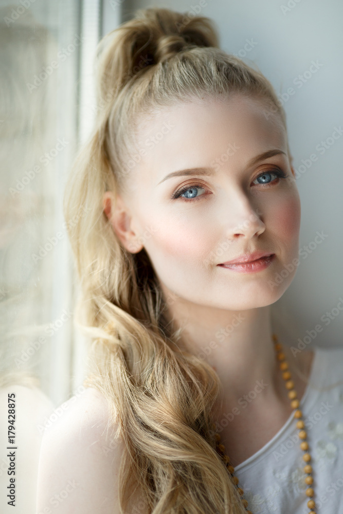 Romantic blonde. Young beautiful cute woman. Beauty girl with long shiny hair, glowing skin and voluminous haircut