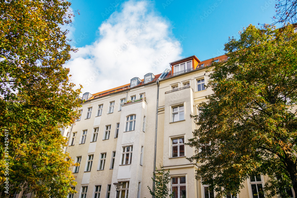 Fototapeta premium residential real estate houses, framed by trees with big clouds