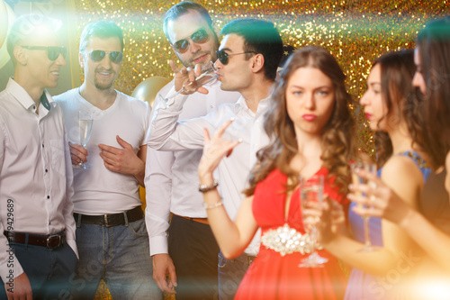 Party people dancing in club. Men and women celebrate a holiday, a birthday or a new year.