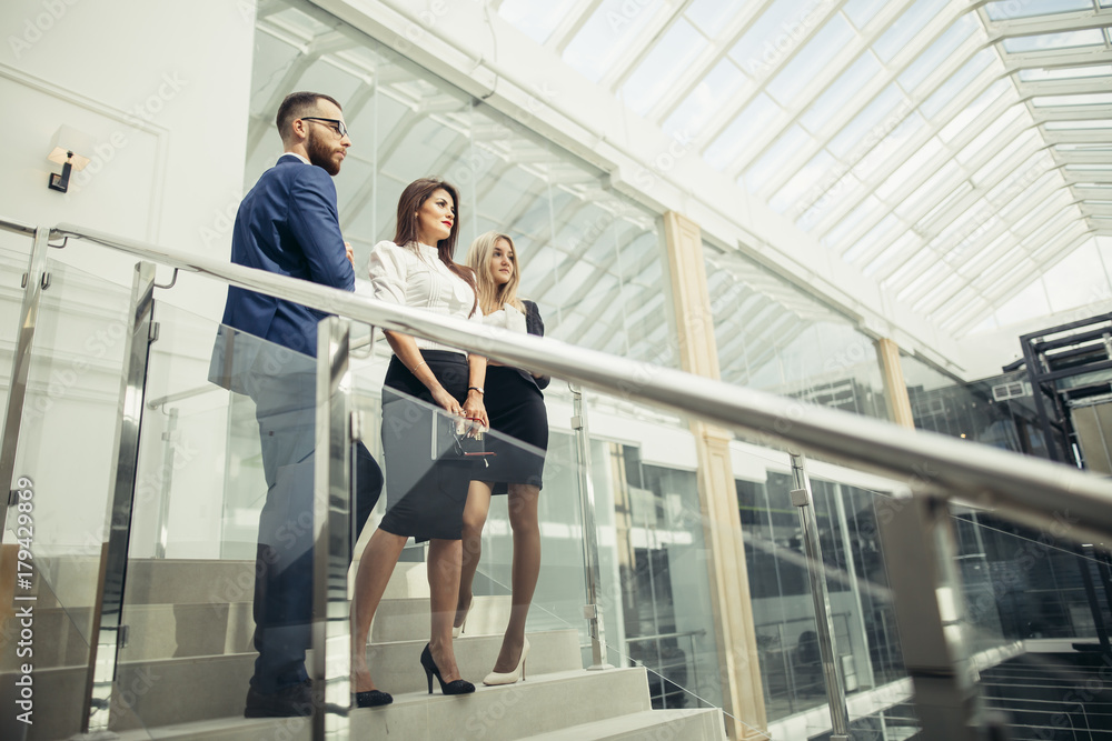 Obraz premium two businesswoman and businessman posing in office