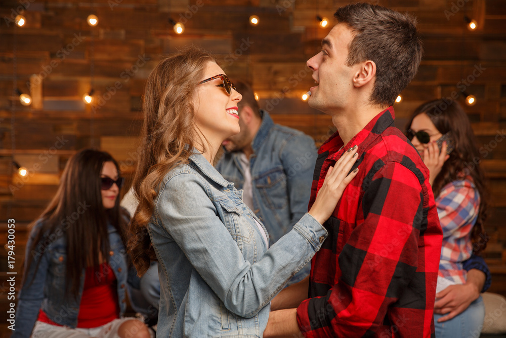 Fototapeta premium Acquaintance and flirtation. A woman and a group of men. Friends discuss the girl