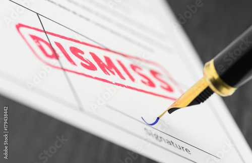 Macro shot of red stamp dismiss and fountain pen on a form.