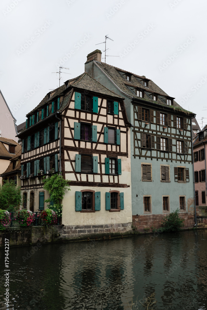 Old house near a canal in Strasbourg, France, with flowers