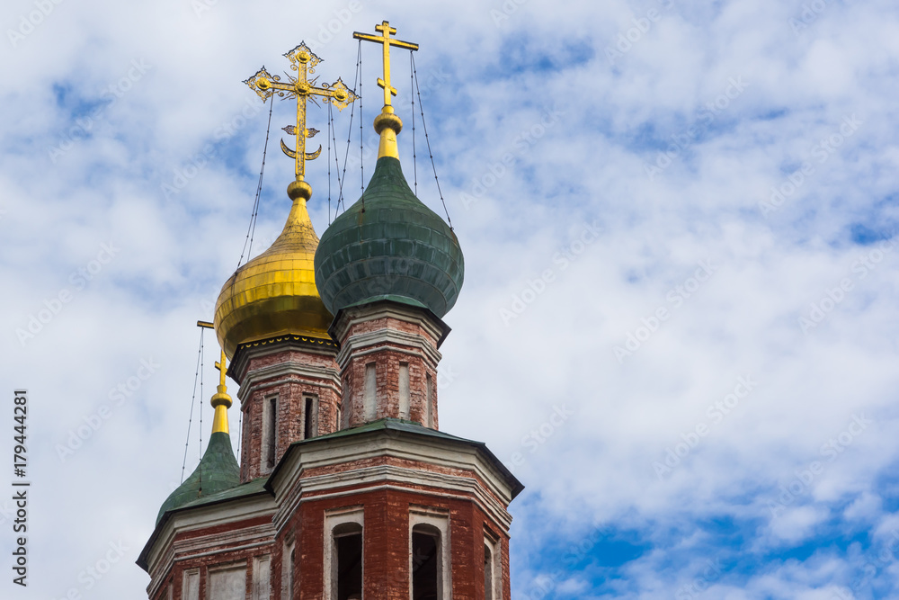 Domes with crosses of an ancient Russian church against a background of a beautiful sky