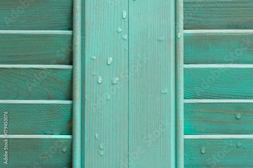 Cyan window with wooden shutter.