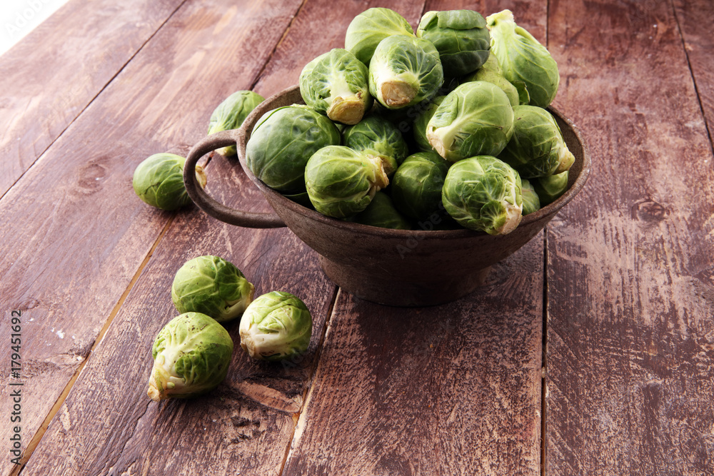 Fresh brussel sprouts over rustic wooden texture and in a vintage bowl. Fresh brussel sprouts over rustic wooden texture and in a vintage bowl.