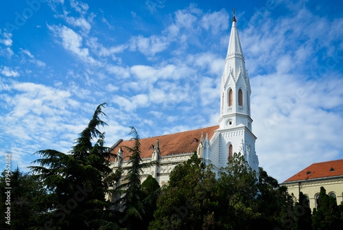 white Catholic cathedral on sunny day with blue sky and clouds