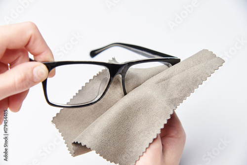 The hands are rubbing the glasses for a view with a napkin