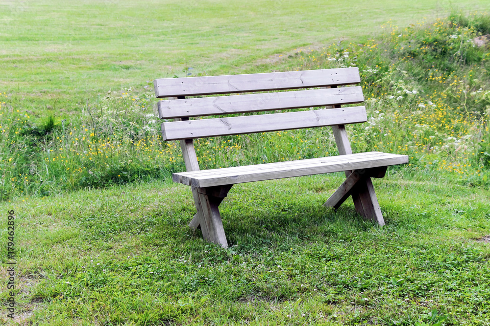empty wooden bench on green grassland empty wooden bench on green grassland