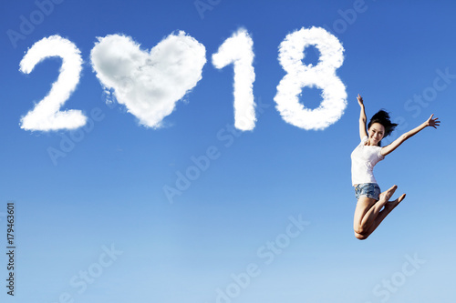 Beautiful woman jumping with numbers 2018