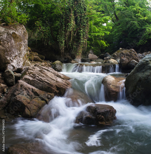 A small waterfall among the rocks on the mountain river