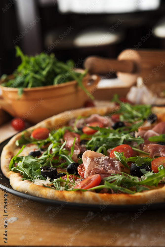 Traditional pizza with prosciutto and arugula Traditional pizza with prosciutto and arugula