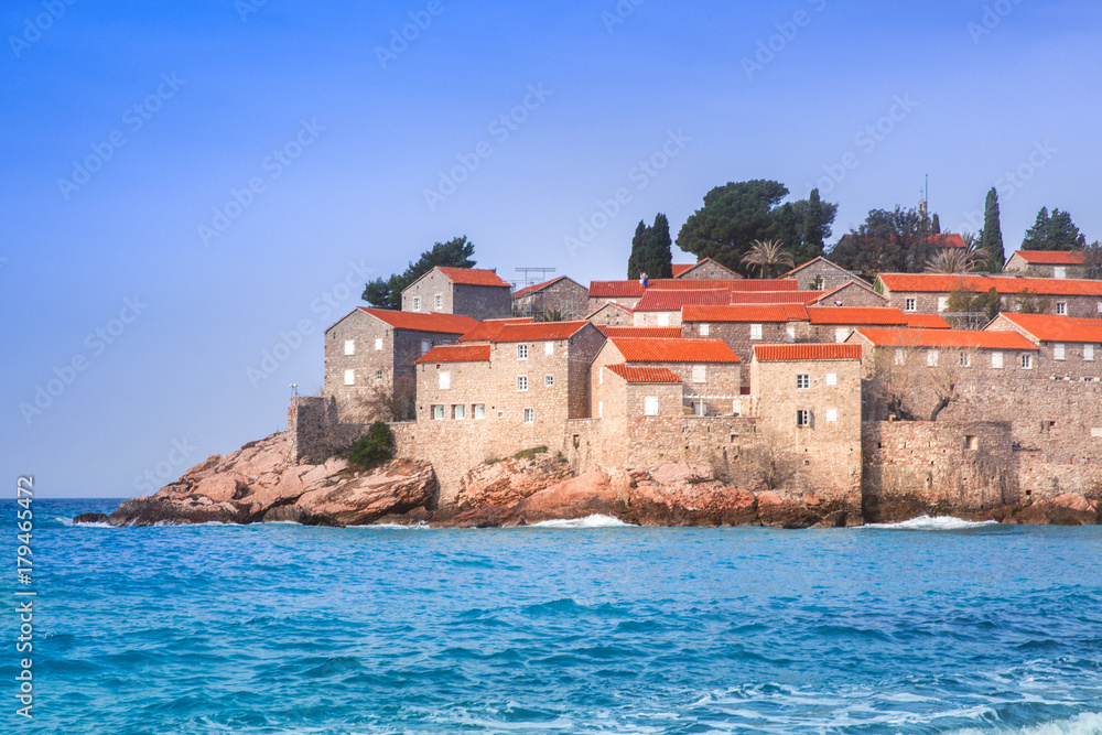 houses with red roofs on island in sea in bright sunny day