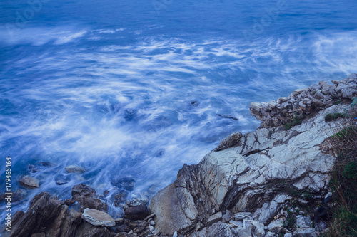 blue waves beat against rocks on long exposure © Aleksei Lazukov