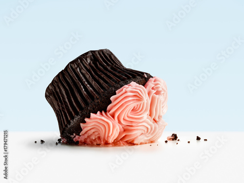 Accident, dropped and smashed cupcake on blue background photo